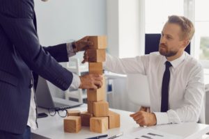 DEux hommes autour d'un bureau résolvent un casse-tête.