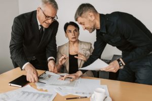 Groupe de trois personnes, deux hommes et une femme, discutant autour d'un projet pouvant être un projet de test.